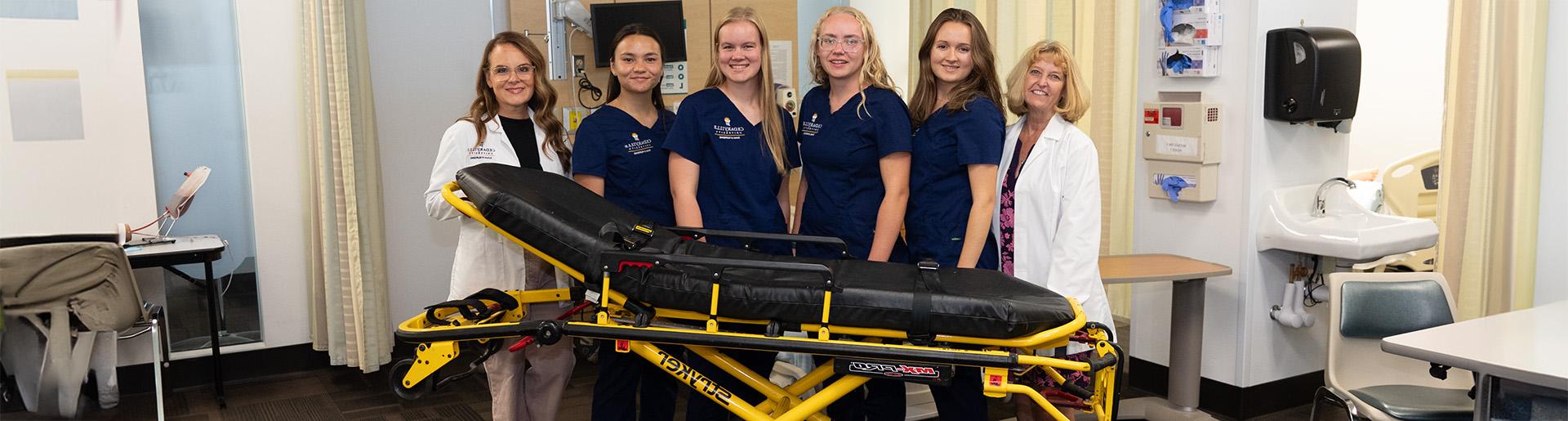 Nursing faculty and students with new Stryker stretcher 1920