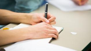 Student writing in a notebook