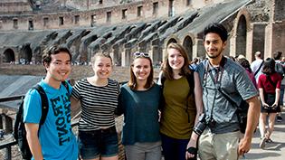 Students stand in front of colosseum